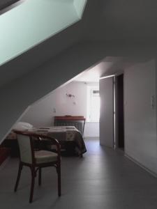 a bedroom with a bed and a table and a chair at Hotel Du Jura in Audincourt