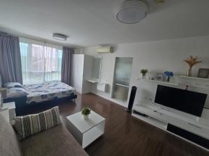 a living room with a couch and a flat screen tv at Downtown Hua Hin Condo with Pool in Hua Hin