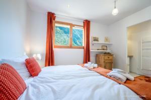a bedroom with a large white bed with a window at Maison Outhera - Chambre d'hôtes in Orcières