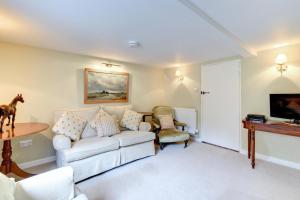 a living room with a white couch and a table at Boot Cottage in Sudbourne
