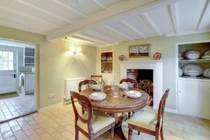 a dining room with a wooden table and chairs at Boot Cottage in Sudbourne