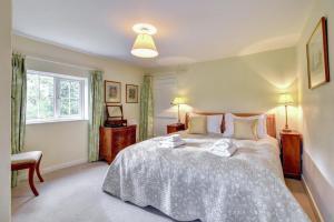 a bedroom with a large bed and a window at Boot Cottage in Sudbourne