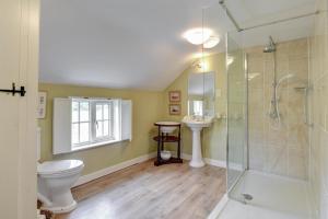 a bathroom with a shower and a toilet and a sink at Boot Cottage in Sudbourne +3 photos