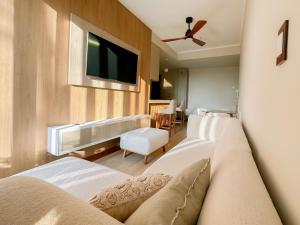 a living room with two beds and a flat screen tv at Alma Residence in Pucallpa