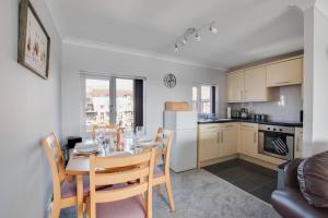 ホーニングにあるMarina Outlookのテーブルと椅子のあるキッチンとダイニングルーム