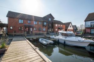 ホーニングにあるMarina Outlookの船が建物の隣の水中に停泊している