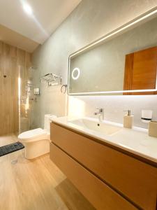 プカルパにあるAlma Residenceの洗面台、トイレ、鏡のあるバスルーム