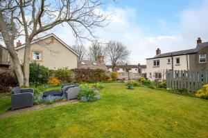 een tuin met banken en bloemen in een tuin bij 3 Bed in North Sunderland oc-nb1980 in North Sunderland