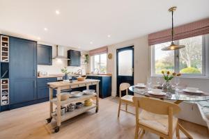 een keuken met blauwe kasten en een tafel en stoelen bij 3 Bed in North Sunderland oc-nb1980 in North Sunderland