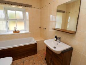 a bathroom with a sink and a tub and a toilet at Barleycorn Cottage in Belford +36 photos