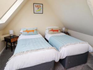 two twin beds in a attic room with at Barleycorn Cottage in Belford