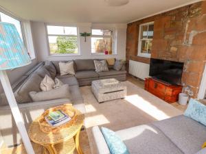 a living room with a couch and a fireplace at Barleycorn Cottage in Belford