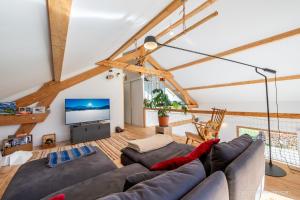 a living room with a couch and a tv at Maison Outhera - Chambre d'hôtes in Orcières
