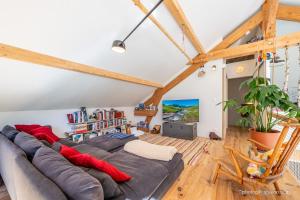a living room with a large couch in a loft at Maison Outhera - Chambre d'hôtes in Orcières +13 photos