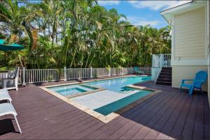 a swimming pool next to a house with trees at Sunset & Sand townhouse in Anna Maria Island