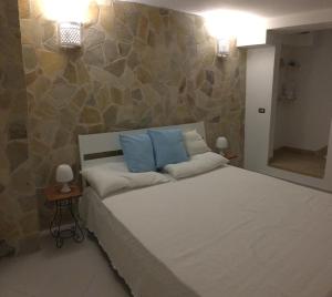 a bedroom with a large bed with two blue pillows at CasadAmare - Puglia Mia Apartments in Monopoli