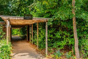 a wooden walkway in a park with a sign on it at Ashorne Hill Leamington Spa in Leamington Spa