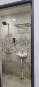 Un baño con un lavabo y un espejo en la pared. en Hotel ShivKashi Inn, en Varanasi