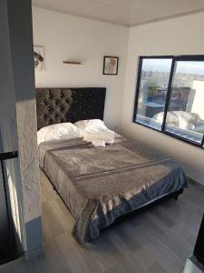 a bedroom with a bed and a large window at Rent Smart Palmira - Tranquilidad y Comfort in La Italia