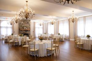 a room with white tables and chairs and chandeliers at The Mimslyn Inn in Luray