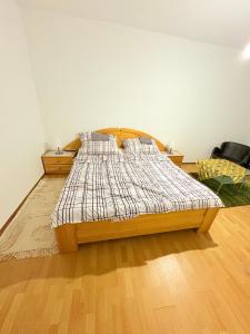 a bed in a bedroom with a wooden floor at Beenie 6 in Linz +6 photos