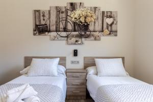 a bedroom with two beds and a bicycle on the wall at Hospital Cruces Metro Bec in Barakaldo
