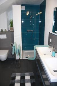 ein Badezimmer mit einer blauen Dusche und einem Waschbecken in der Unterkunft Premium Ferienloft Dreßler Fulda in Fulda
