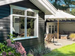 a house with a deck and an umbrella at 6 person holiday home in Gilleleje-By Traum in Gilleleje +18 photos