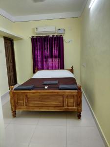 a bedroom with a wooden bed in a room at Villa de valentin in Puducherry