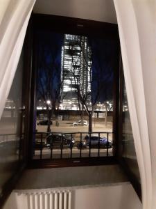 a window with a view of a city at night at Porta Susa Rooms in Turin