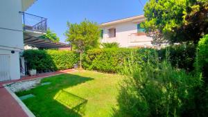 a backyard with a green lawn in front of a house at Appartamento trilocale cod 462 in Marcelli