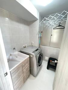 a laundry room with a washing machine and a sink at Condominio Ricaurte in Ricaurte