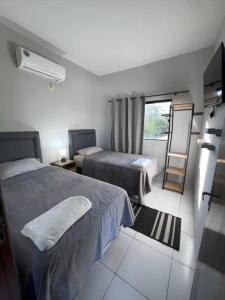 um quarto de hotel com duas camas e uma janela em La Rosa Loft em Ciudad del Este