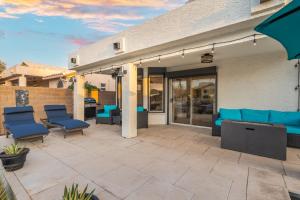 a patio with blue chairs and a building at Modern 3BR Oasis Pool Views Fire Pit & BBQ in Glendale