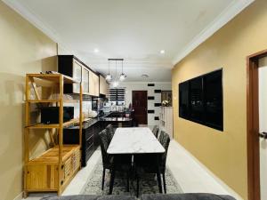 a kitchen and dining room with a table and chairs at FS Homestay Jitra in Jitra