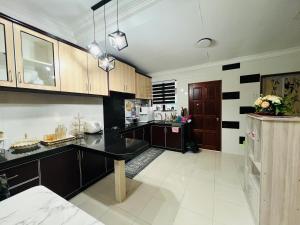 a kitchen with wooden cabinets and a black counter top at FS Homestay Jitra in Jitra +3 photos
