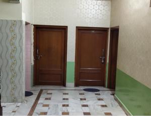 2 porte marroni in una stanza con pavimento piastrellato di Shekhawati heritage a Jhunjhunūn