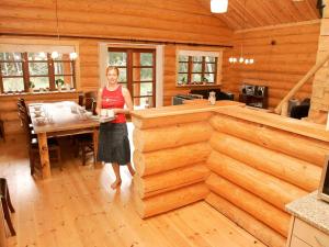 a woman standing in the kitchen of a log cabin at 10 person holiday home in Hadsund-By Traum in Odde