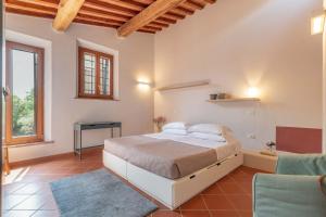 a bedroom with a bed and a table and a chair at NORMA, Charming Apartments La Spinetta Nel Borgo in Terricciola