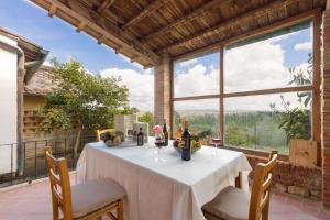 a table with wine bottles and glasses on a balcony at NORMA, Charming Apartments La Spinetta Nel Borgo in Terricciola