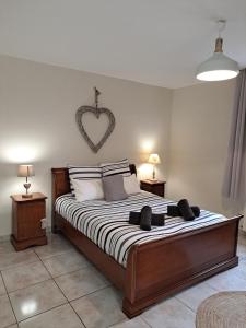 a bedroom with a bed with a heart on the wall at Laurette Maison familiale, Vallée de la Somme in Sailly-Laurette