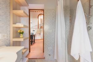 a bathroom with a shower with a toilet and a staircase at NORMA, Charming Apartments La Spinetta Nel Borgo in Terricciola