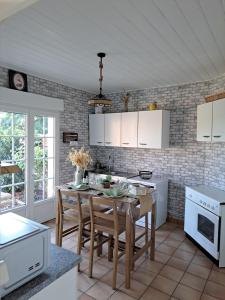 a kitchen with white cabinets and a table with chairs at Laurette Maison familiale, Vallée de la Somme in Sailly-Laurette