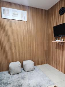 two white stools in a room with a wooden wall at Anugrah Syariah Homestay Ciperna in Cirebon