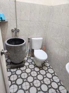 a bathroom with a toilet and a bath tub at Anugrah Syariah Homestay Ciperna in Cirebon
