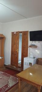a room with a kitchen with a table and a door at Hotel Gostynnyi Dvir in Sharhorod