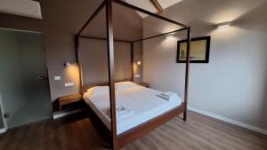 a bedroom with a four poster bed with white sheets at Villa Piediprato in Spinetoli