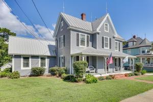 una casa gris con una bandera en el patio delantero en Historic Waterfront Home with Dock in Reedville!, en Reedville