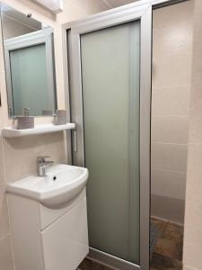 a white bathroom with a sink and a shower at Duende in Pointe-Noire