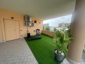 a living room with a green rug and a treadmill at Oasi Urbana in Casoria